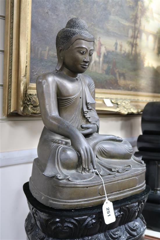 A 19th century Burmese bronze Buddha inset ebony and ivory eyes seated on bespoke lotus-carved polished wood column